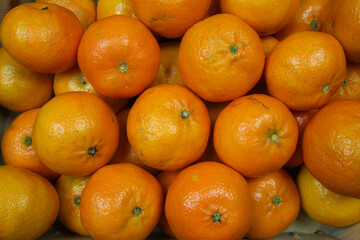 Close up of many ripe raw orange mandarins for natural food background (focus on center)
