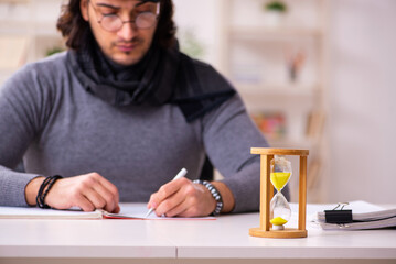 Young male writer in time management concept