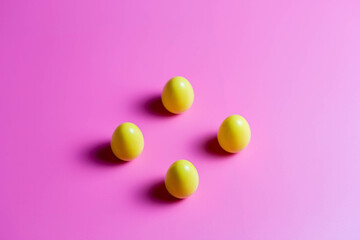 Four Yellow Plastic Easter Eggs on pink background
