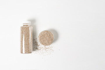 Chia dry in a glass plate and in a bottle, top view, for text place on a light background . vegetarian healthy food with omega and vitamins. superfood for weight loss and self-care