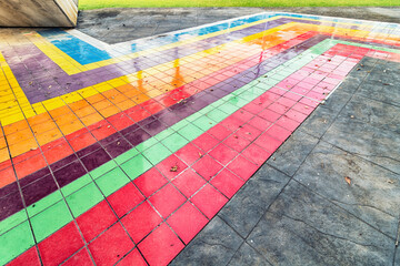 Multicolored sidewalk. Close up of a street with colored tiles in a park.