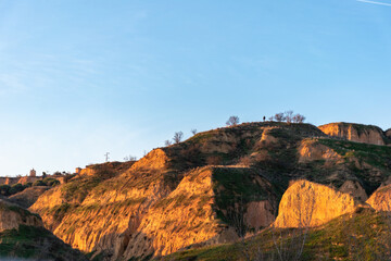 Persona caminando por en monte con un bonito atardecer, con el cielo y nubes