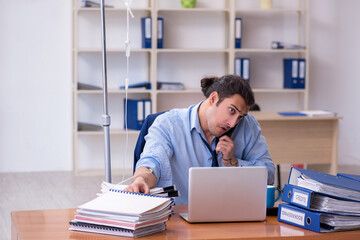 Fototapeta premium Young male employee suffering at workplace