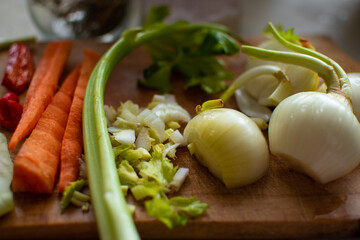 Ingredients for cooking a stewed dish: pepper, carrot, celery, cabbage and onion on wooden cutting board