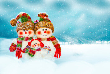 Three snowmen on a snowy background.