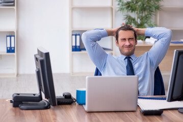 Young male employee unhappy with excessive work