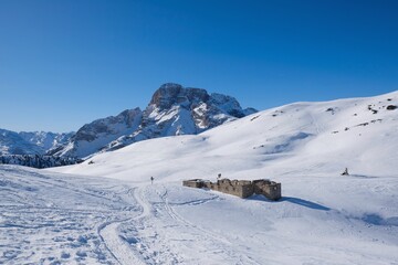 Fototapeta na wymiar Mountain view with ruin of fort from World War I in winter sunny scenery, during climbing to Platzwiese (Piazza Prato) Strudelkopf Mountain. Dolomites, Italy