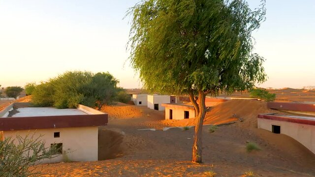 Al Madam ghost town landscape, village buried in sand dunes, hunted by evil djinn, in the desert of Sharjah, United Arab Emirates, sunset.