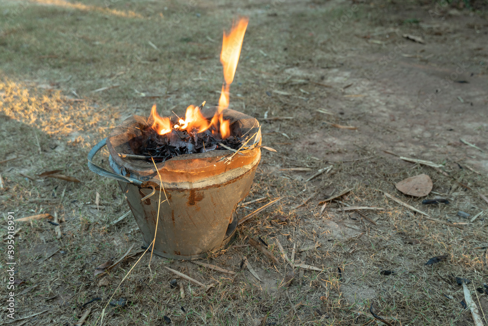 Wall mural .way of life of rural people make a fire with dry twigs, dry leaves next to the house to bbq fresh f