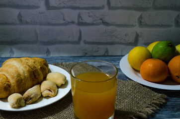 Still life with fresh fruits and glass of juice on the wooden background
