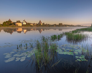 Obraz premium Old fortress in the village of Staraya Ladoga on the Volkhov River, foggy summer morning