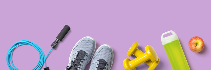 Fitness equipment on a lilac background with copyspace