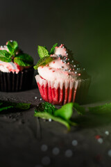 sponge cap cakes with cream of cream and cream cheese are decorated with mint leaves and sprinkled...
