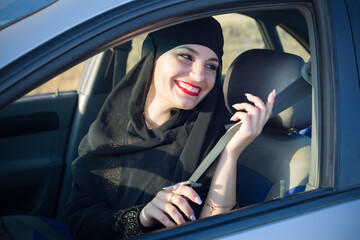 Fototapeta na wymiar Muslim woman fastening car seat belt