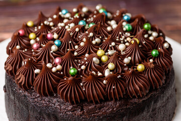 A rich indulgent chocolate cake top with chocolate swirls and brightly coloured candy