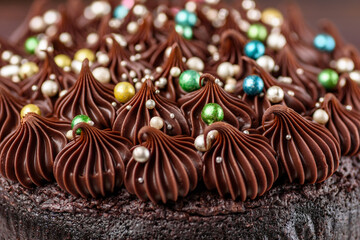 A rich indulgent chocolate cake top with chocolate swirls and brightly coloured candy