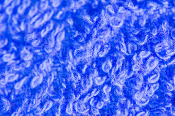 Defocused fluffy wool texture on blur background, abstract blue color background. Blurred knitted fabric texture, shallow dof