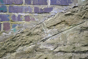 Detail of Old Masonry Wall Divided Diagonally with Rough Textured Stone & Black Brick