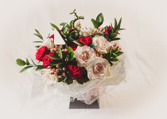 A spring flower arrangement with both red and white naomi roses