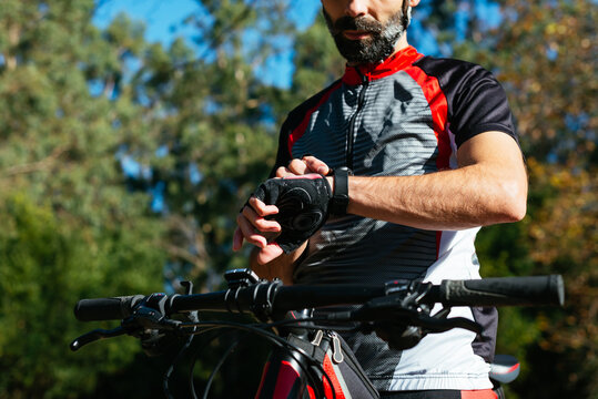 Anonymous young cyclist using his smartwatch.