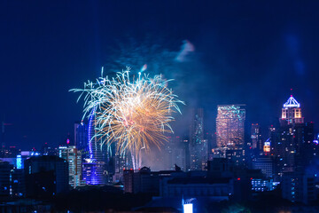 Colorful Firework with cityscape night light view of Bangkok skyline at twilight time..New Year celebration fireworks,  Bangkok city,Thailand.Fireworks light up to sky at Christmas & New Year festival