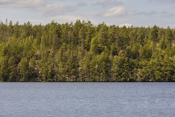 Naklejka premium Beautiful lake view on blue sky with white clouds background. Beautiful summer nature backgrounds. Sweden, Europe.