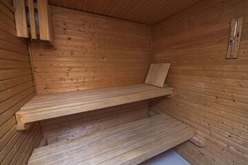 Fototapeta na wymiar Close up view of sauna room interior. Wooden walls and seats. Health concept.