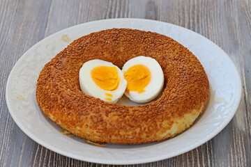 Sesame bagels in a white plate and a cut egg in the middle