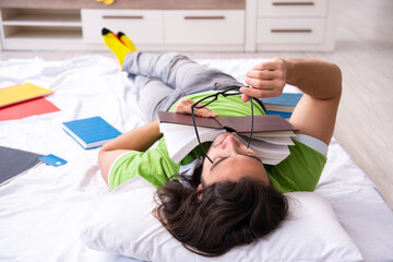 Young male student preparing for exams at home