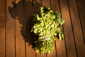 green rucola salad on wood background