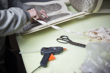 Worker makes furniture restoration with hot glue gun and tape