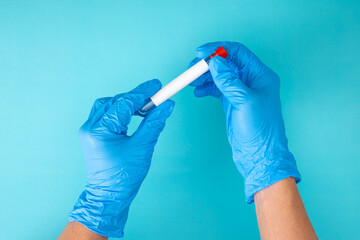 hand in blue gloves holding a test tube