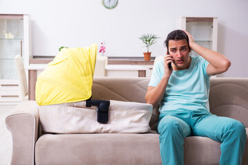 Young male parent looking after newborn at home