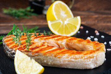 Grilled salmon fish on stone board. Salt atlantic salmon fried on grill with lemon