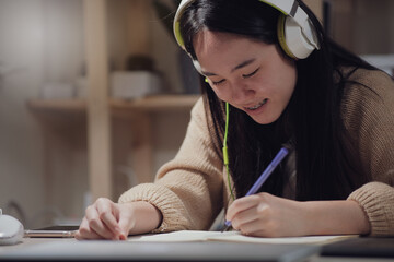  Asian teen girl listening to music with headphone,