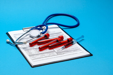 Clipboard with paper blank form with medical tools on blue background with cope space
