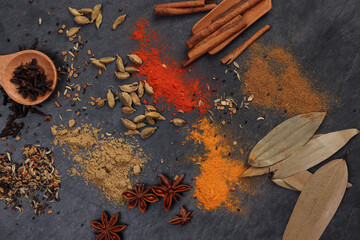 Mix variety spice cinnamon cardamom clove bay leaf wooden chilli cumin turmeric powered on black...