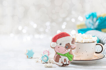 Christmas gingerbread in glaze in the form of a bull. Christmas symbols, on table with New Year's decor.