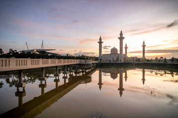 Fototapeta na wymiar Tengku Ampuan Jemaah mosque, Bukit Jelutong Shah Alam during sunrise with reflection from the lake