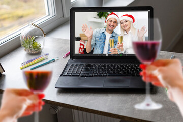 Happy woman making a toast on video call celebrating christmas with glass of wine online during coronavirus outbreak - Focus on wine glass