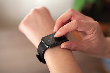 Close-up of a woman checking time on her smart watch.Modern clock concept.Background woman hand wear wrist watch.
