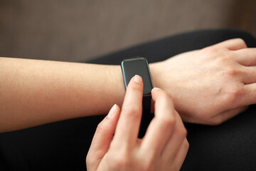 Close-up of a woman checking time on her smart watch.Modern clock concept.Background woman hand wear wrist watch.