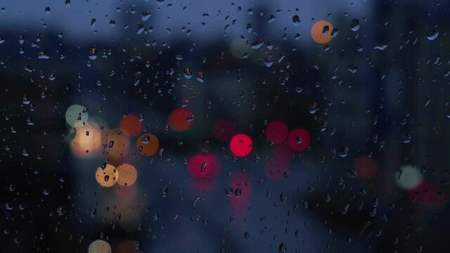 rainy days, rain drops on the window surface with traffic bokeh in background 