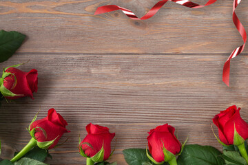 Red rose background for Valentines day, Mothers day, Birthday card. Flowers with ribbons on the wooden table flat lay