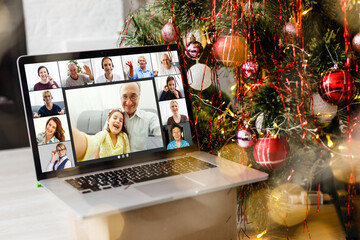 Naklejka na ściany i meble laptop with video call and christmas tree with lights in the background