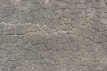 たくさんの亀裂の入ったアスファルトの写真