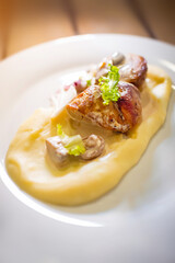 Meat meal on a plate decorated with meshed potatoes