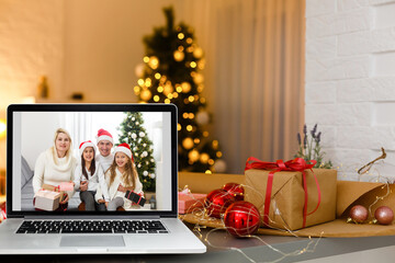 laptop with video call and christmas tree with lights in the background