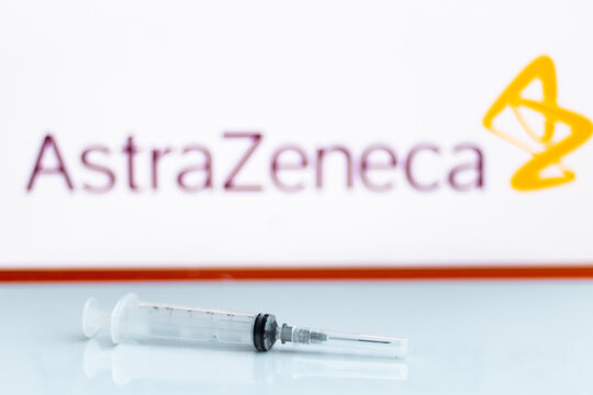 Empty Syringe Placed On A Reflective Surface Against AstraZeneca Logo. Oxford University And AstraZeneca Are Working On COVID-19 Vaccine.