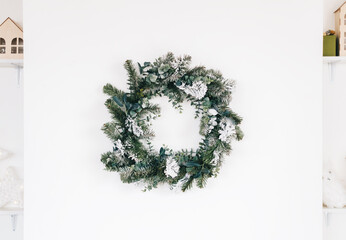 Christmas wreath on white wall in living room.